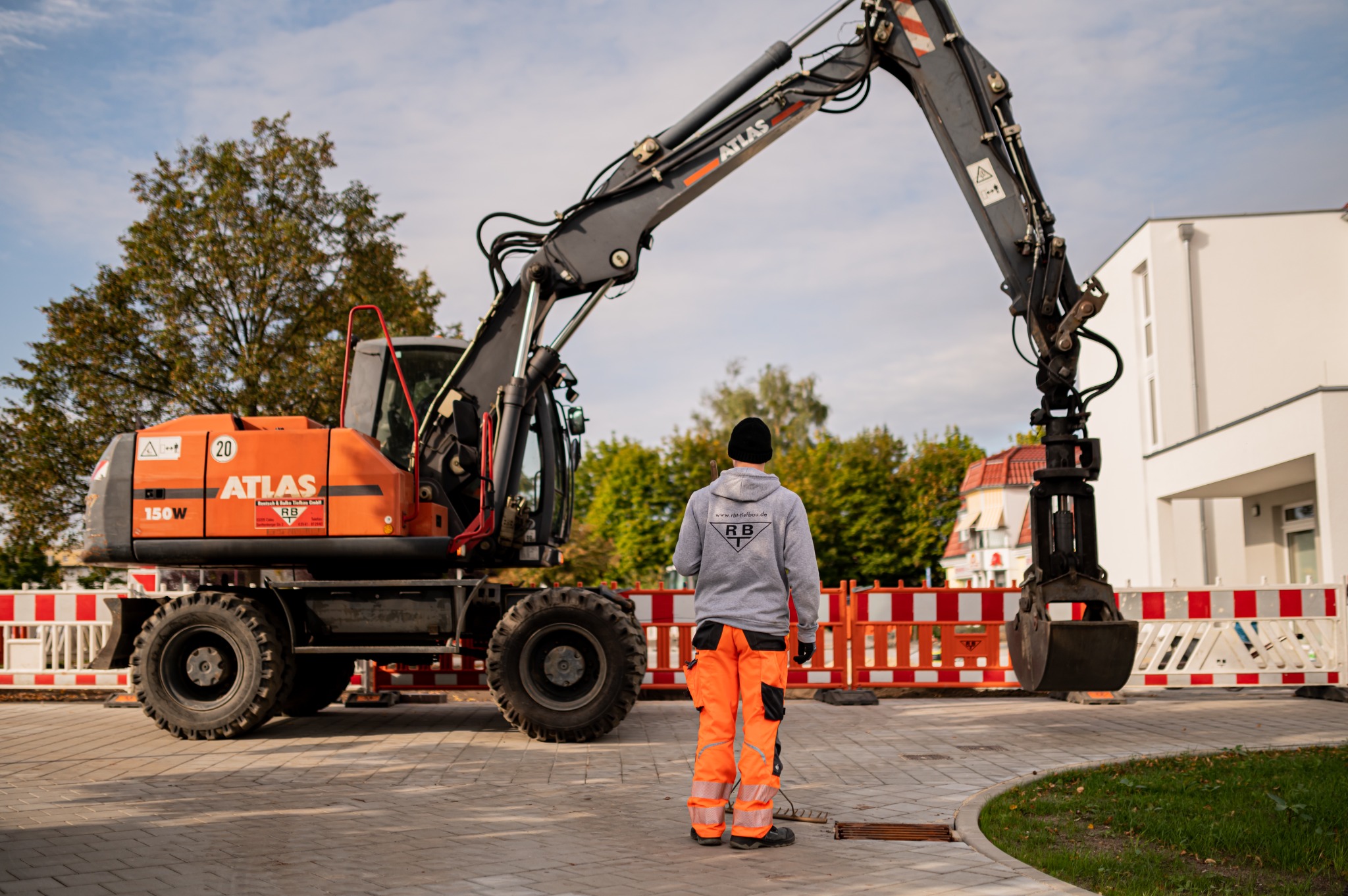RBT-Mitarbeiter vor einem orangefarbenen Atlas-Mobilbagger