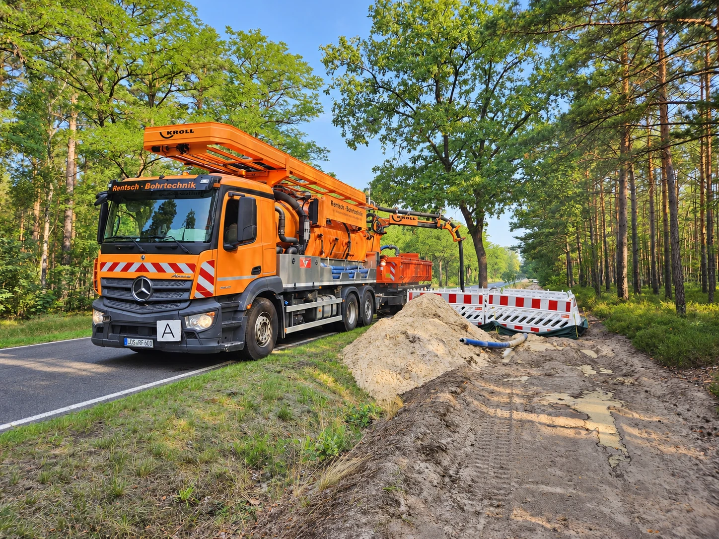 Orangefarbener RBT-Saugbagger an einer Leitungstrasse